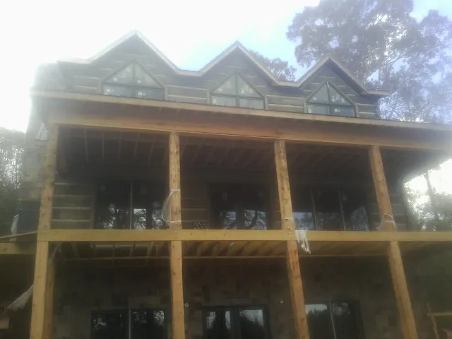 Dormers and porch framing on a large log home under construction — Roof Coating work by our crew in Ceres